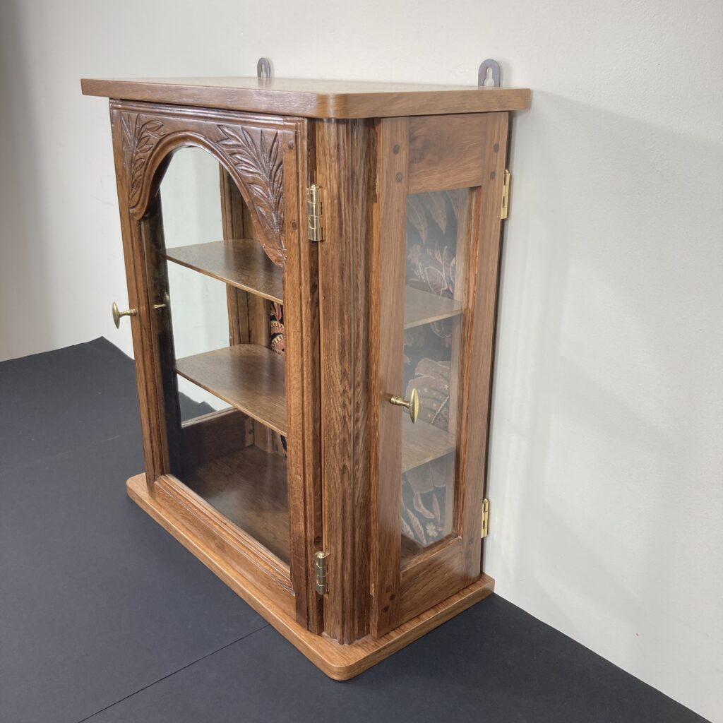 Vitrine murale en chêne issue d’une ancienne horloge, vue de trois quarts