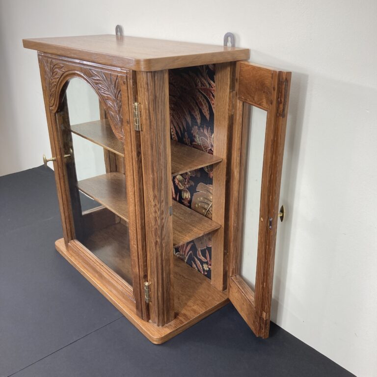 Vitrine murale en chêne avec porte latérale ouverte et intérieur à décor végétal