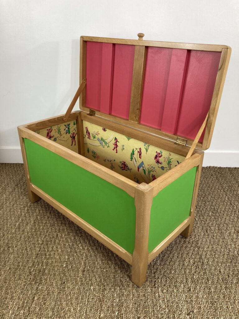 Coffre à jouets ouvert avec intérieur coloré et tissu vintage