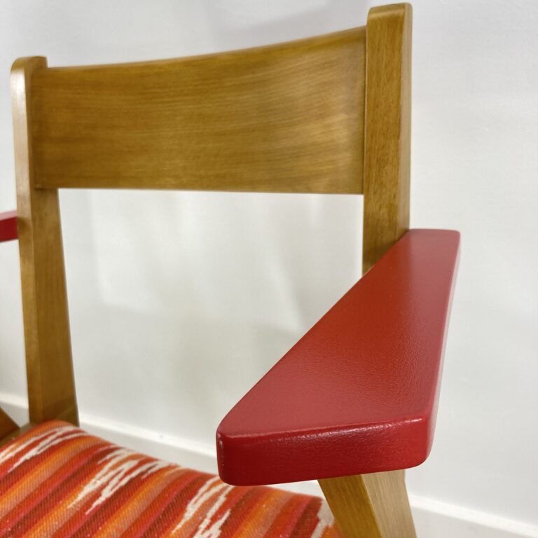 Détail de l'accoudoir rouge d'un fauteuil bridge vintage restauré