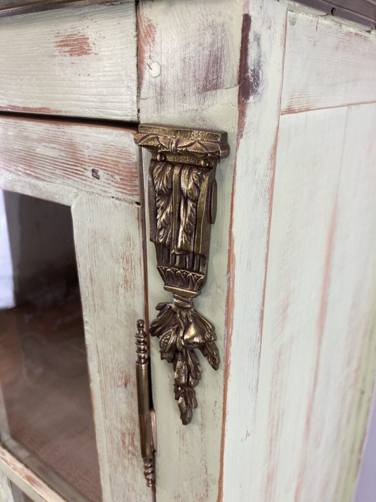 Détail d'un ornement en laiton et d'une charnière de l'armoire vitrine