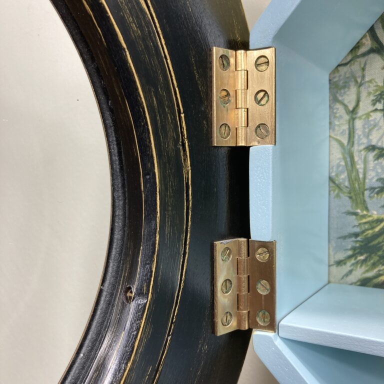 Détail des charnières en laiton de la vitrine œil-de-bœuf