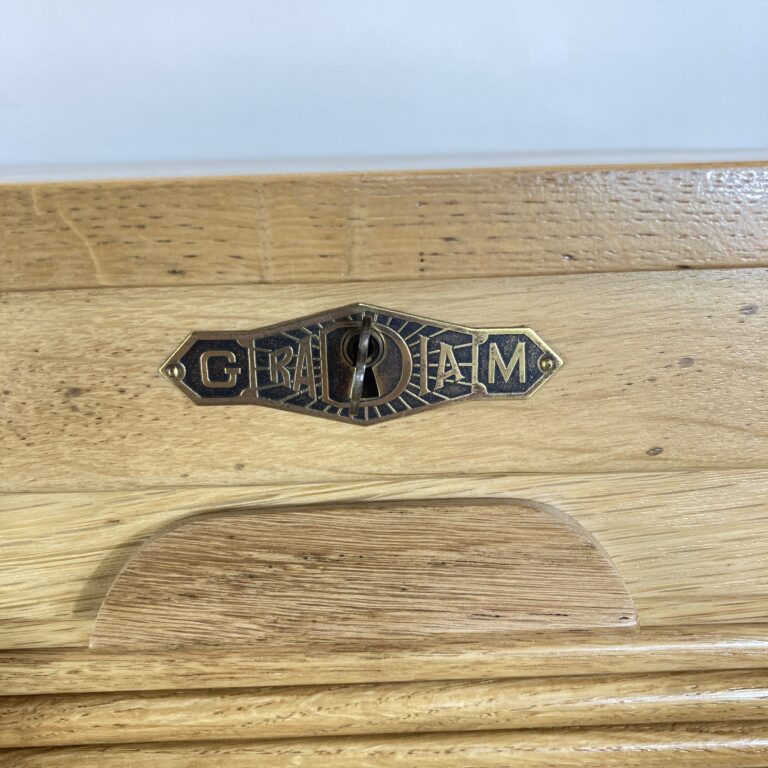 Détail de l'entrée de serrure marquée GM Radia sur le bureau en chêne