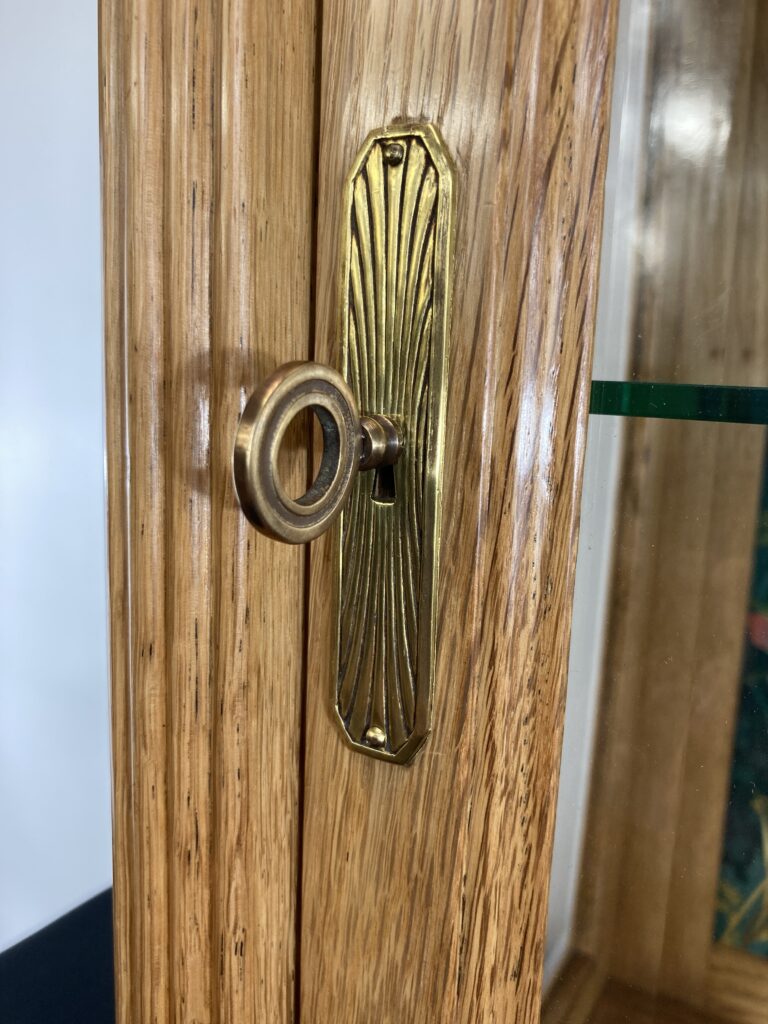 Détail de la serrure et de la clé de la vitrine en chêne