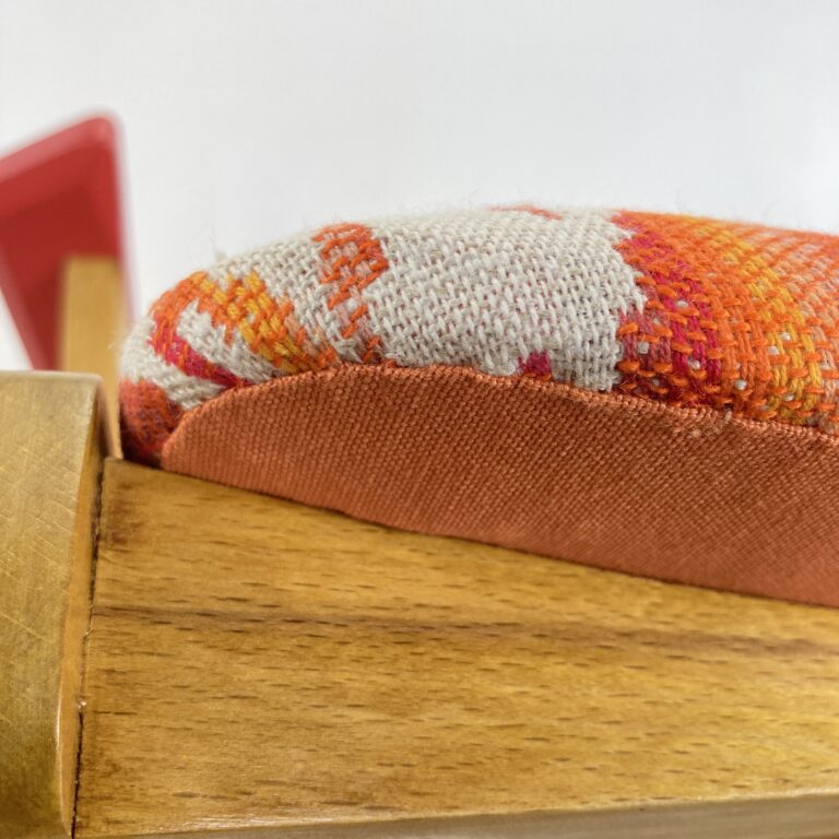 Détail de la couture et de la garniture d'un fauteuil bridge restauré