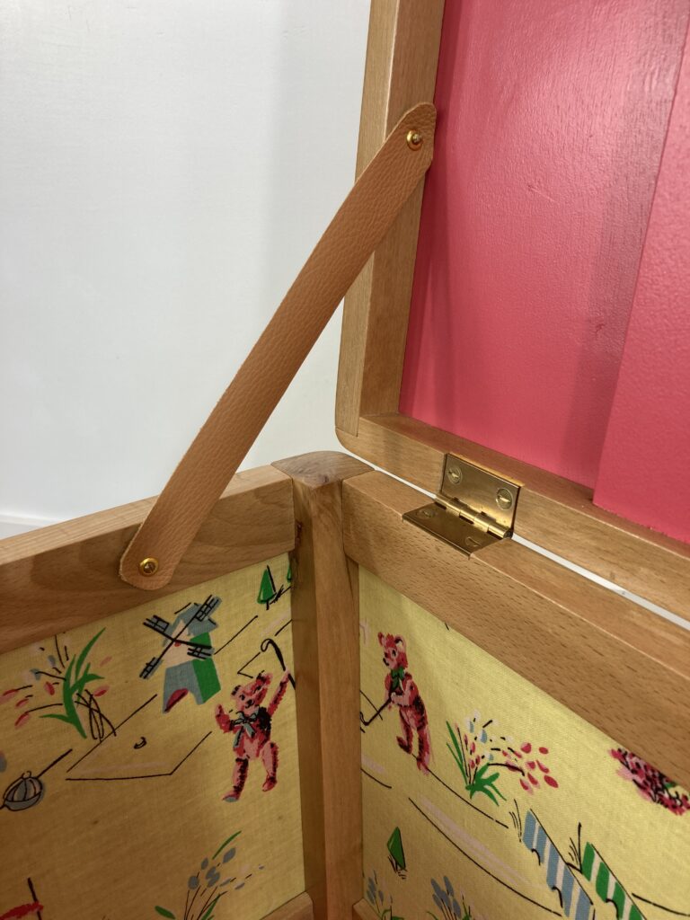 Détail de la sangle en cuir maintenant le couvercle du coffre à jouets