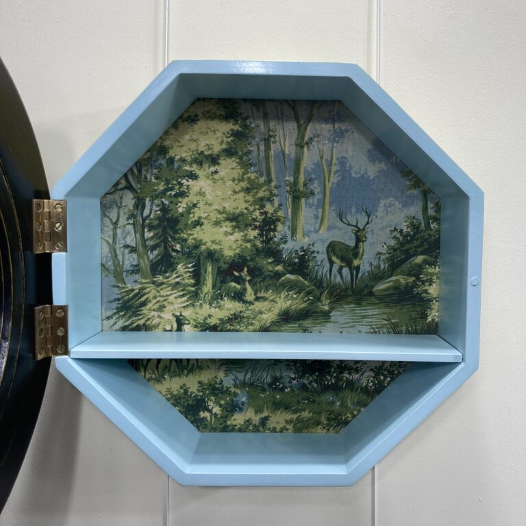 Intérieur de la vitrine œil-de-bœuf avec étagère et décor de forêt