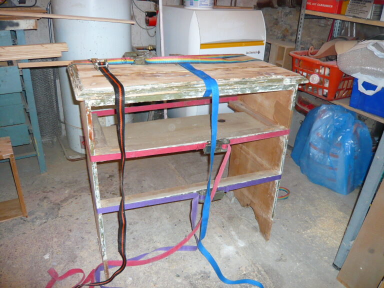 Structure du meuble maintenue par des sangles pendant le recollage
