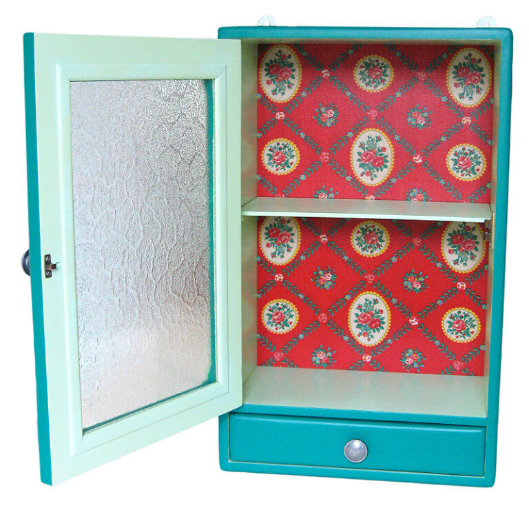 Armoire de toilette ouverte avec intérieur vert clair et décor floral rouge