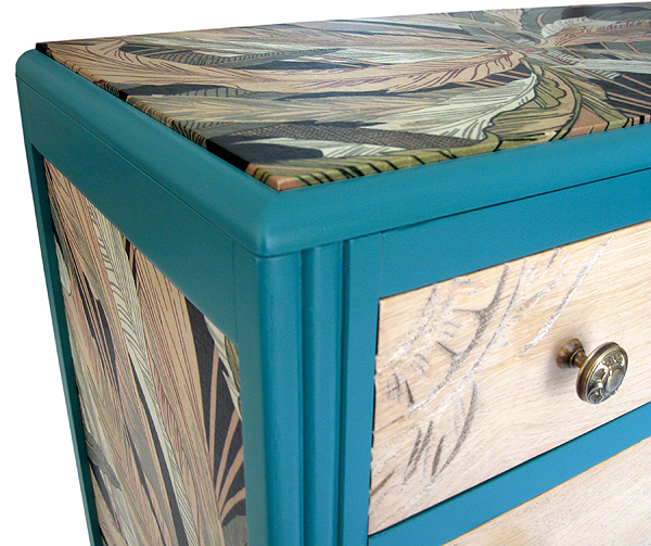 Détail du dessus, du tissu à motif végétal et d'un tiroir de la commode restaurée